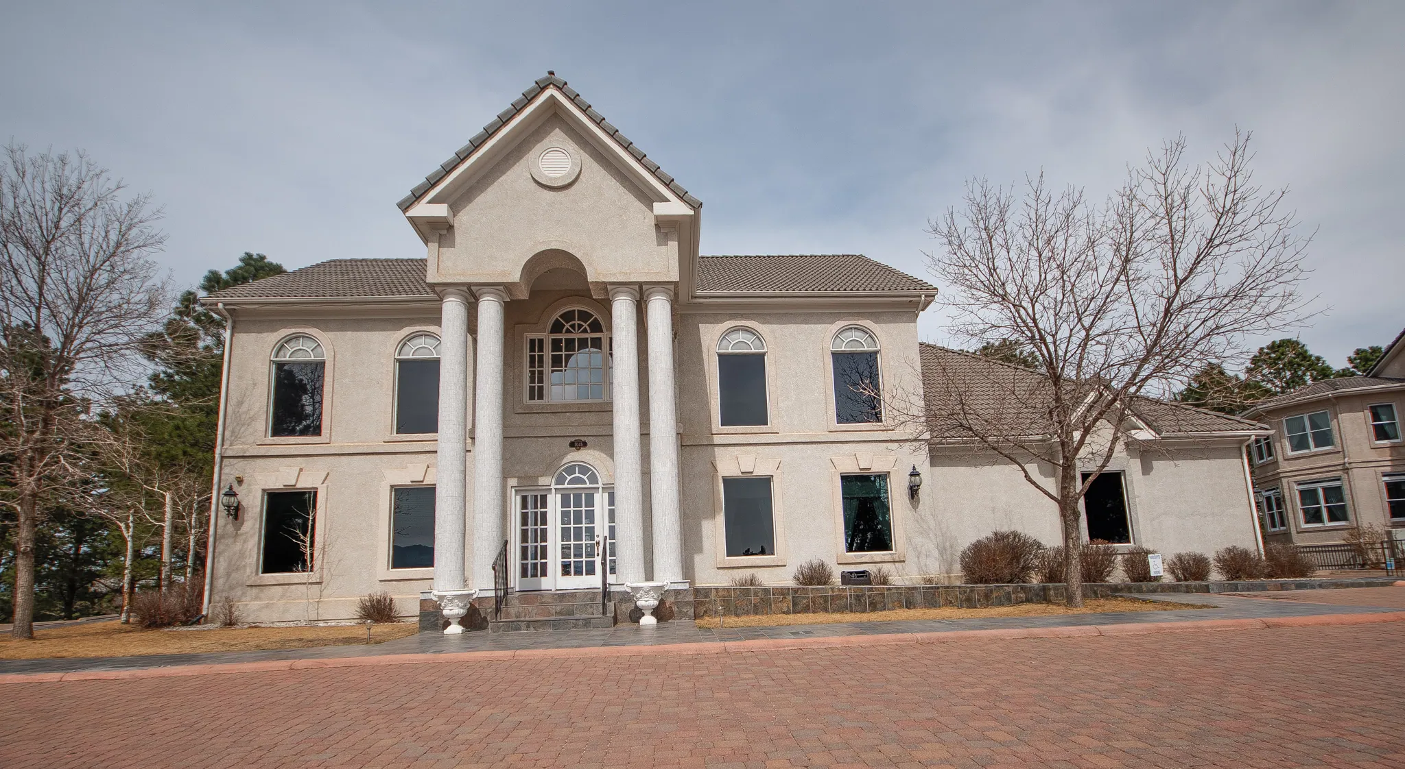7045 Campus Drive: white two-story office building with a columned entrance and brick-paved drive