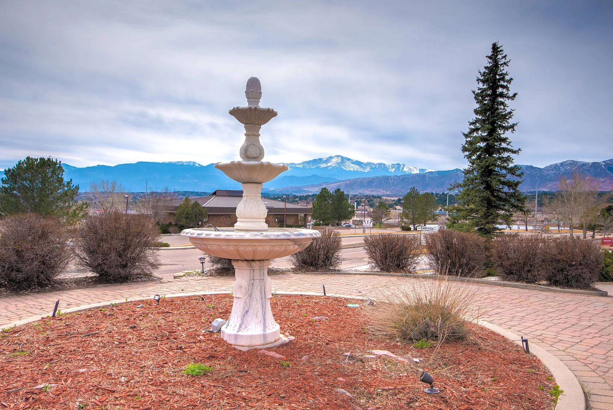 Fountain on the Muhr Professional grounds with Pikes Peak and the Front Range in the distance